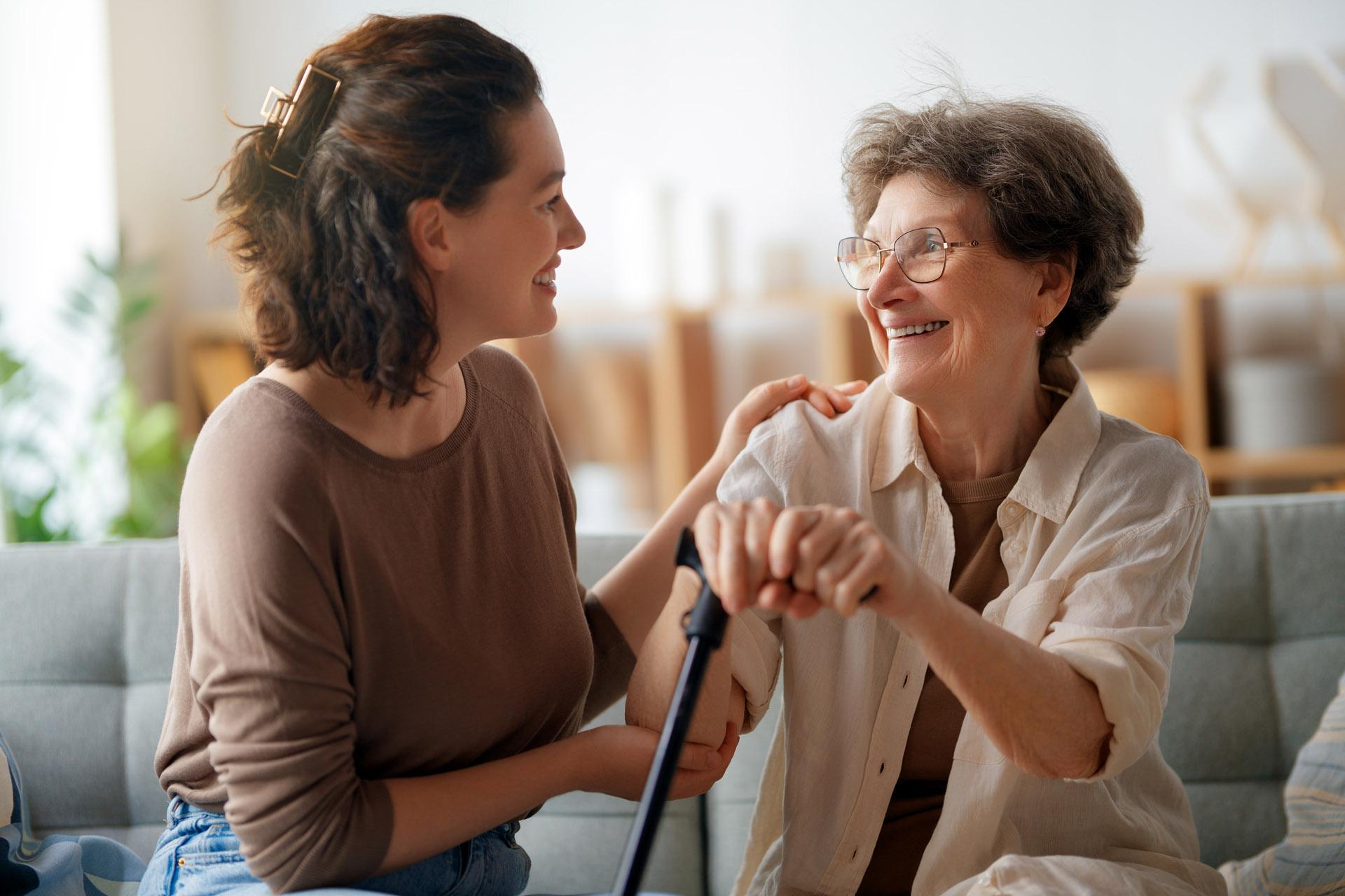 Alltagshelferin lacht mit einer Seniorin